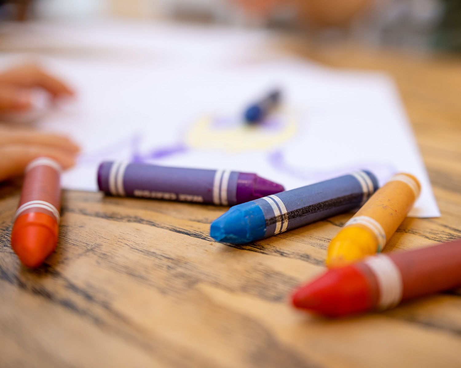 Colorful crayons on a wood table.