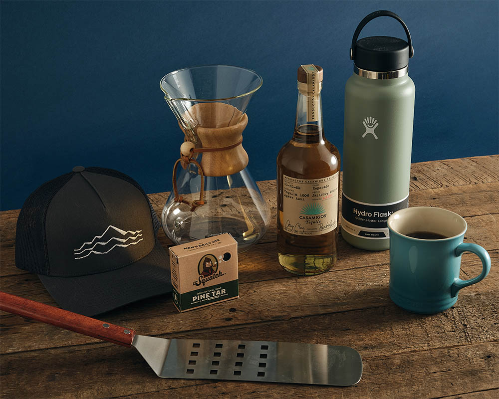 Various Father's Day gifts including a water bottle, coffee mug, coffee carafe, and hat.