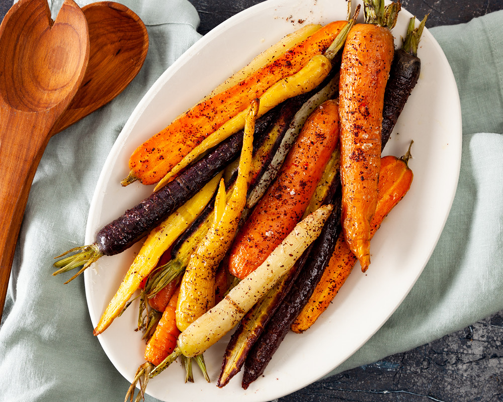 Roasted rainbow carrots on white serving platter