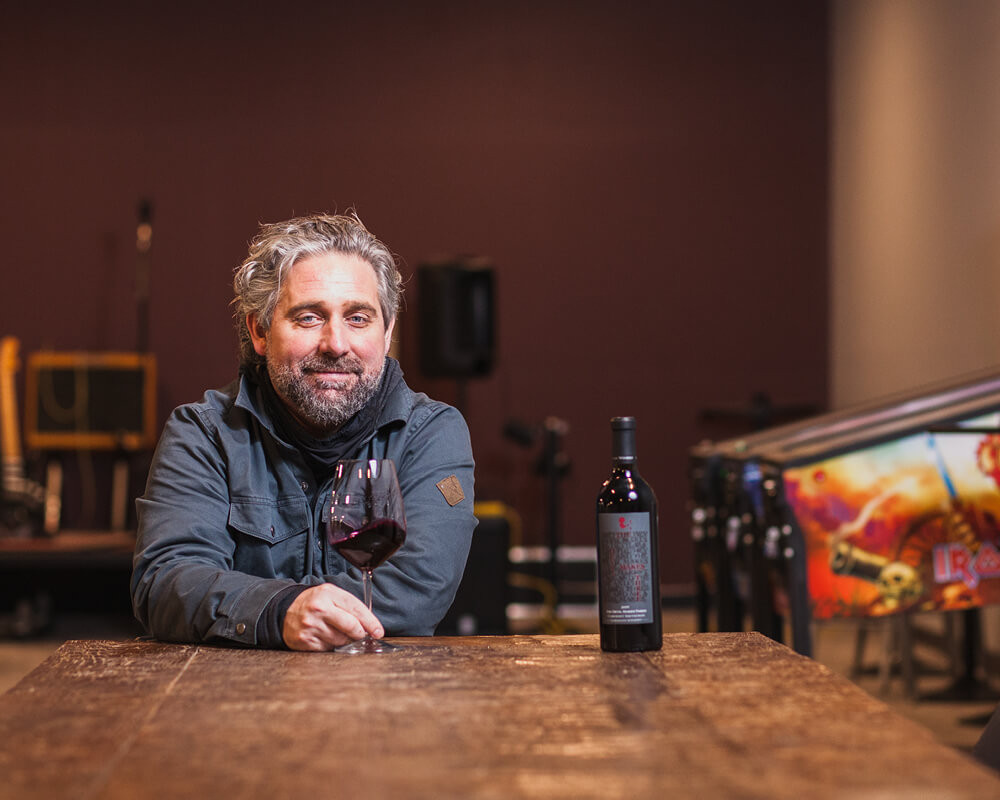 Chris Gorman with wine glass and bottle