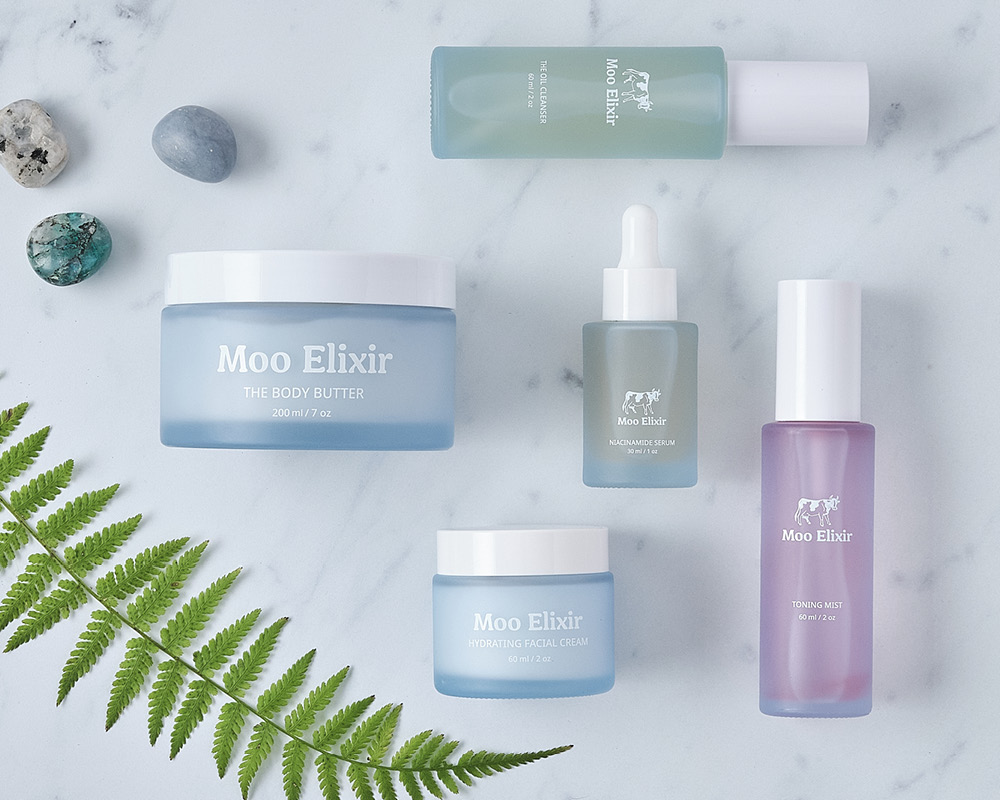 Moo elixir body care styled with stones and a fern