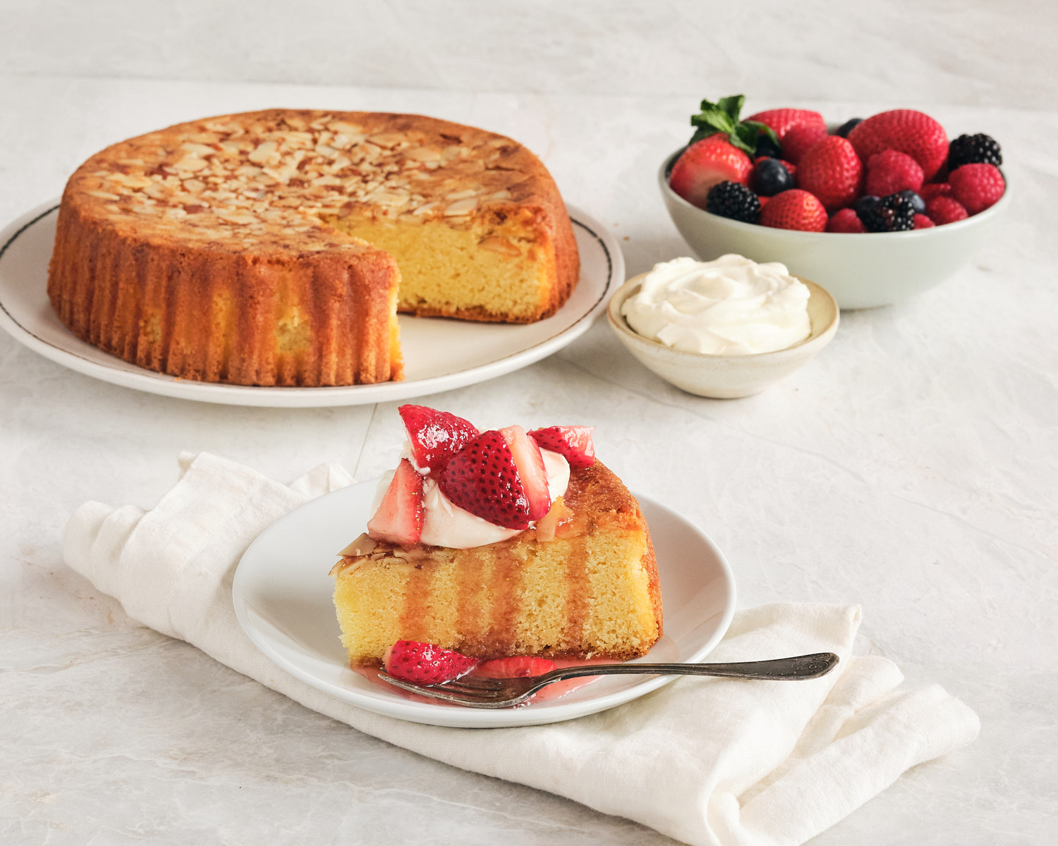 almond cake with whipped cream and berries
