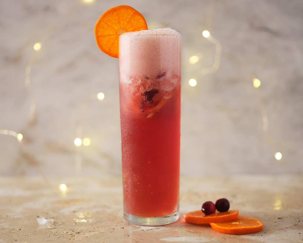 Satsuma Blush Sparkler Mocktail staged with Christmas lights