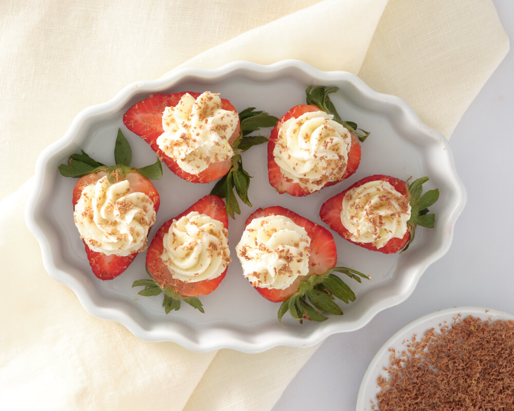 strawberries with cheesecake filling on top and chocolate sprinkled