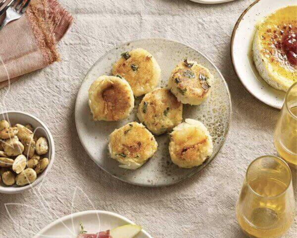 Overhead image of a round plate with crab cakes piled on top.