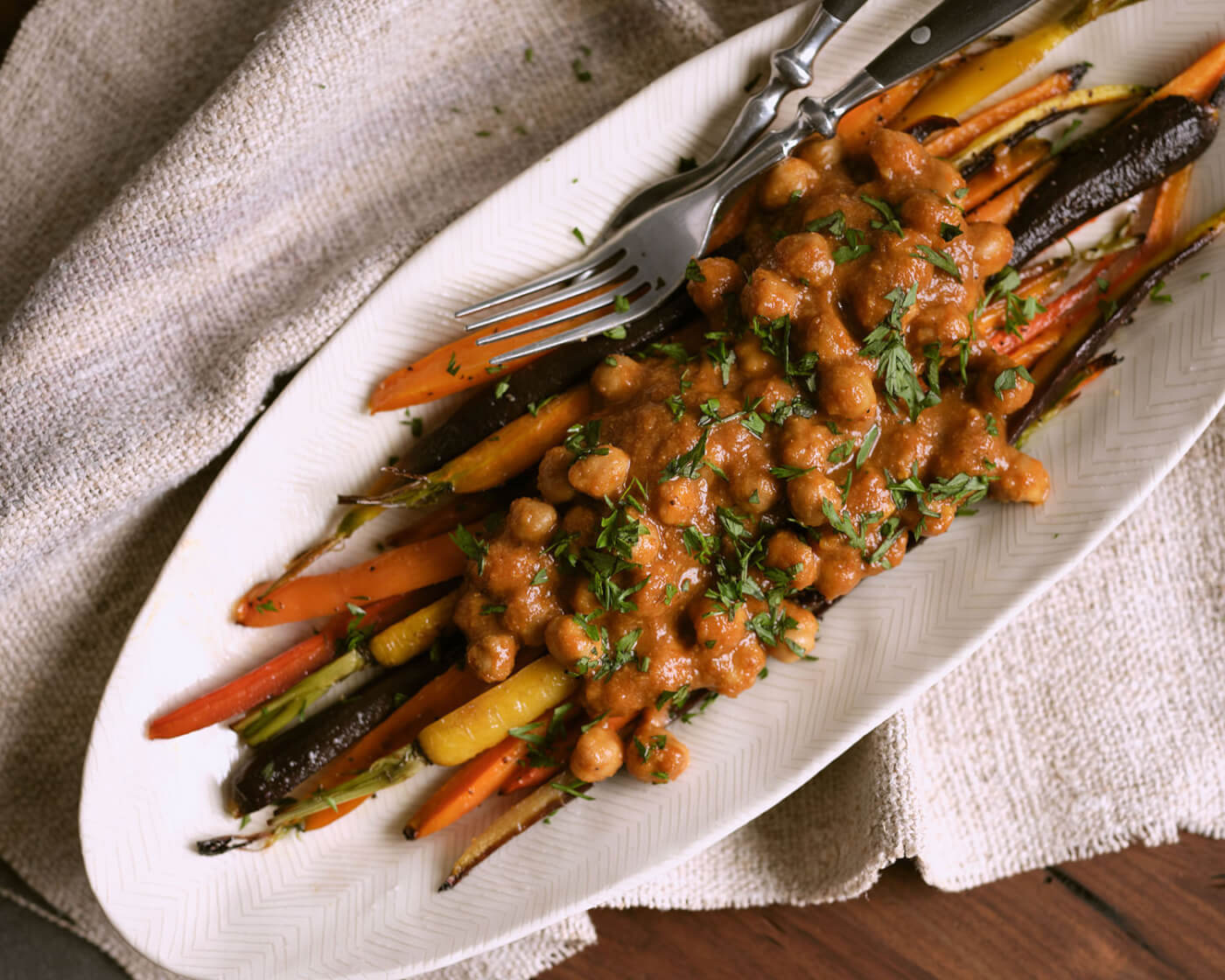 Roasted carrots covered in saucy chickpeas.