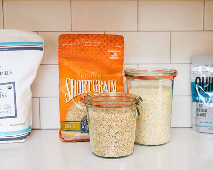 Packages of rice on a pantry shelf.