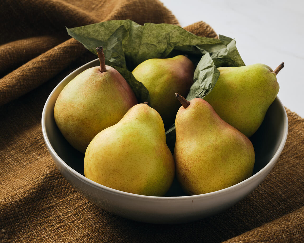 Bowl of pears on a linen runner