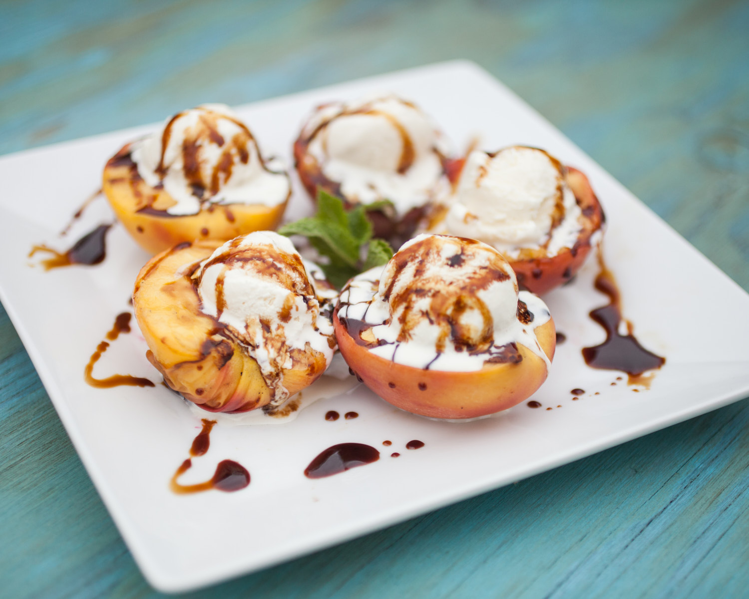 grilled peaches with ice cream on a platter