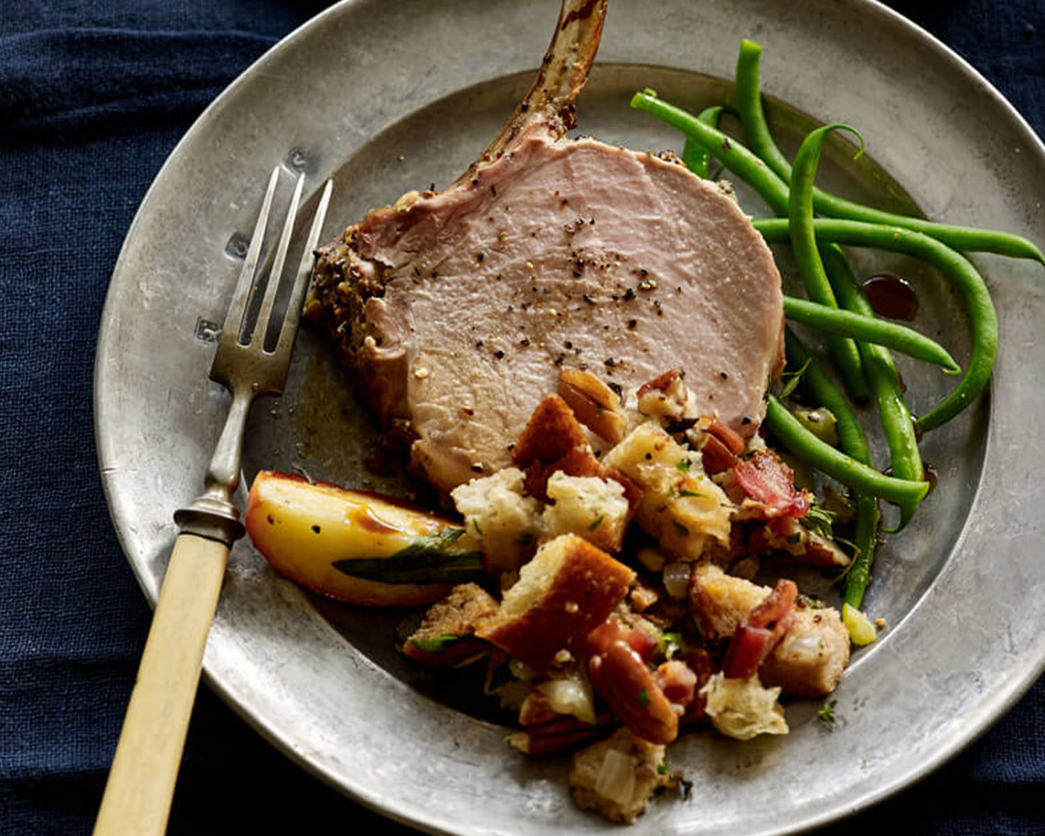 Pork chop on a plate with potatoes and green beans