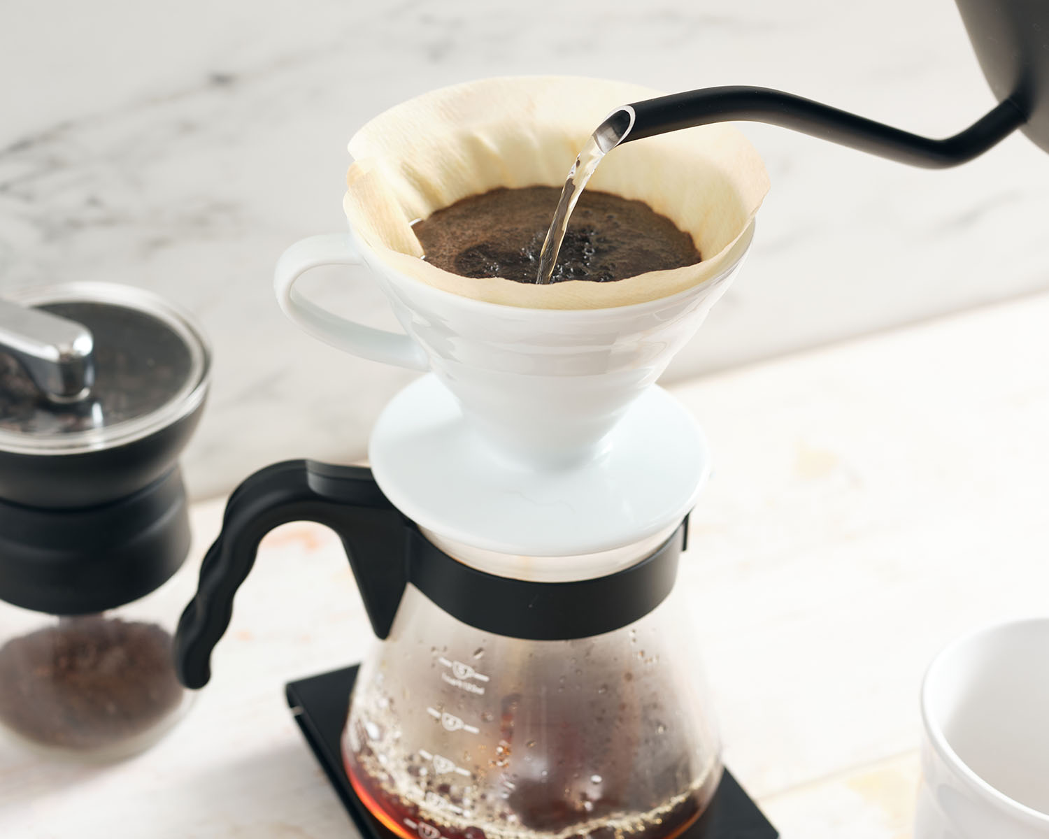 Hot water pouring over a coffee filter filled with ground coffee.