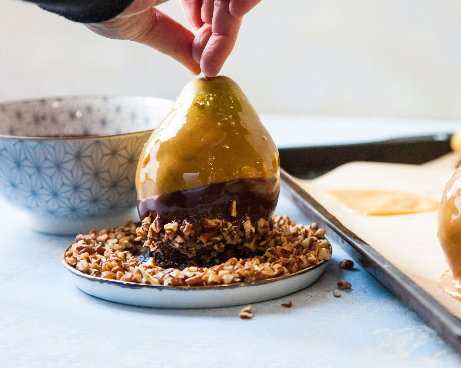 Pear dipped in chocolate, caramel, and chopped nuts