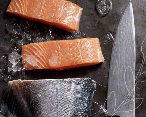 Fresh salmon on a cutting board with a knife.