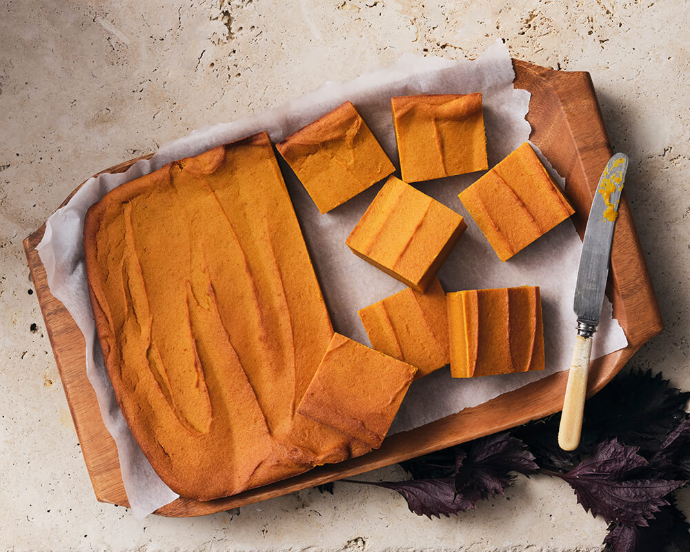 pan of pumpkin butter mochi, half of it cut into squares