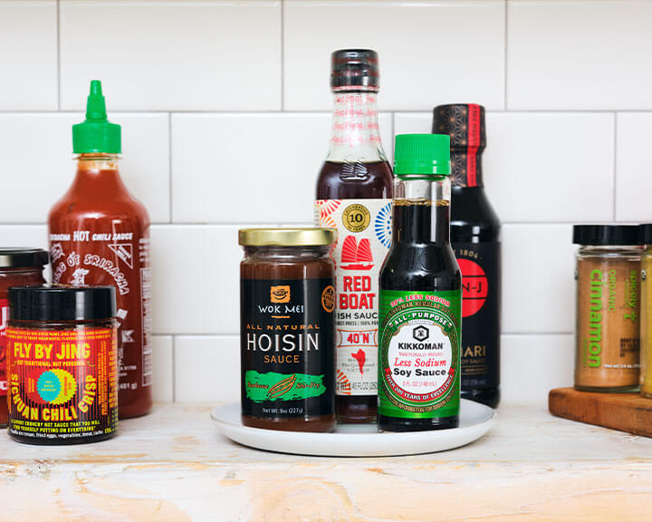 Containers of various soy sauces on a pantry shelf.