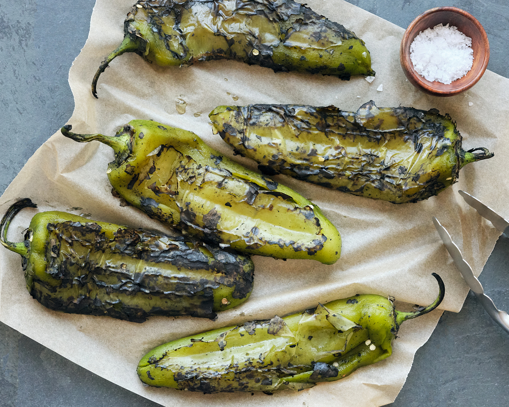 Roasted hatch chiles laid out on parchment paper