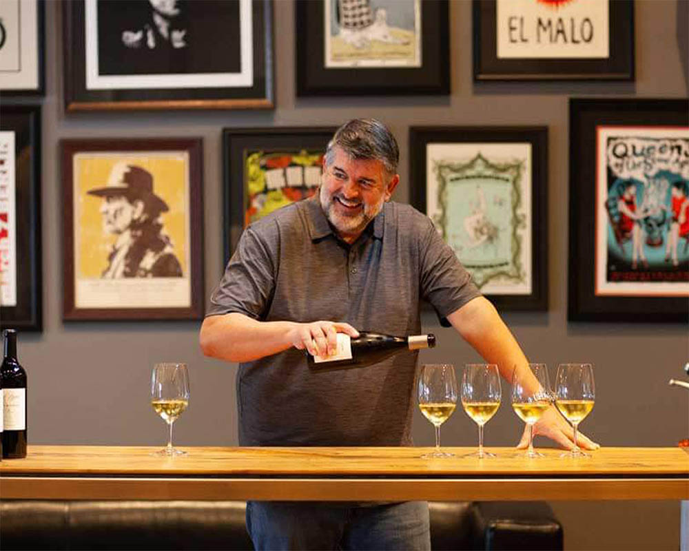 Mark McNeilly pouring wine in a tasting room