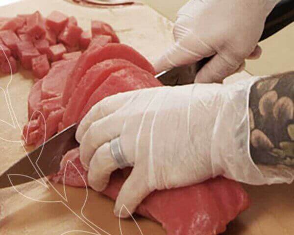 Chef cutting slices of fresh tuna.