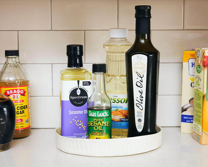 Various cooking oils on a pantry shelf.