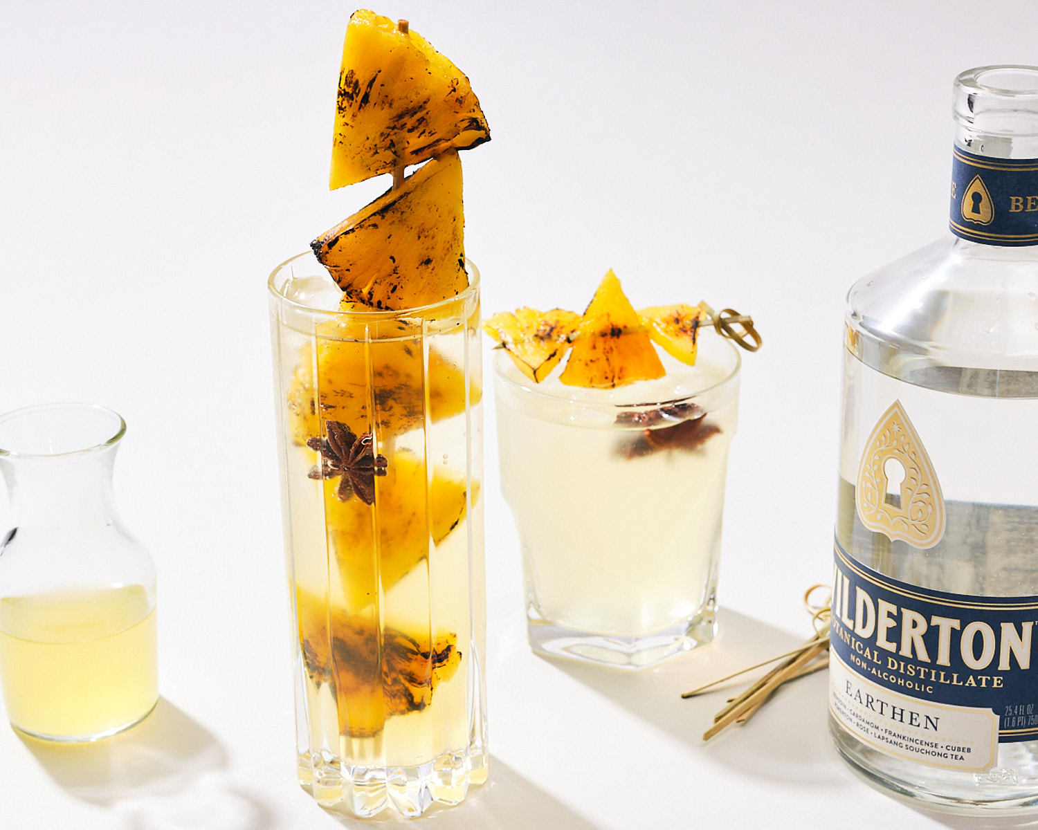 grilled pineapple na cocktail with an open bottle of Wilderton