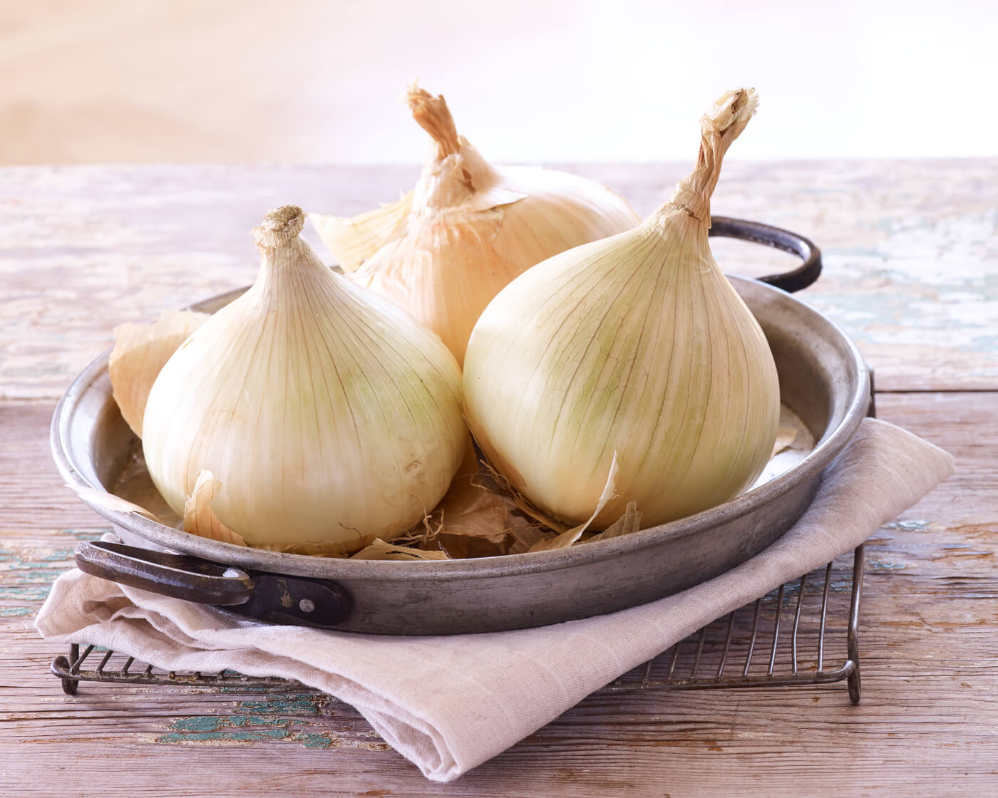 Three whole onions in a shallow dish