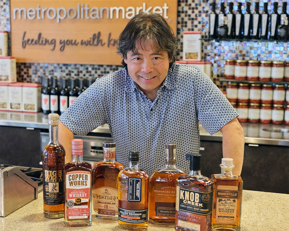 Mark Takagi and a variety of whisky in bottles