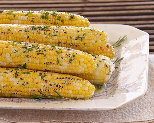 six ears of cooked corn on a platter