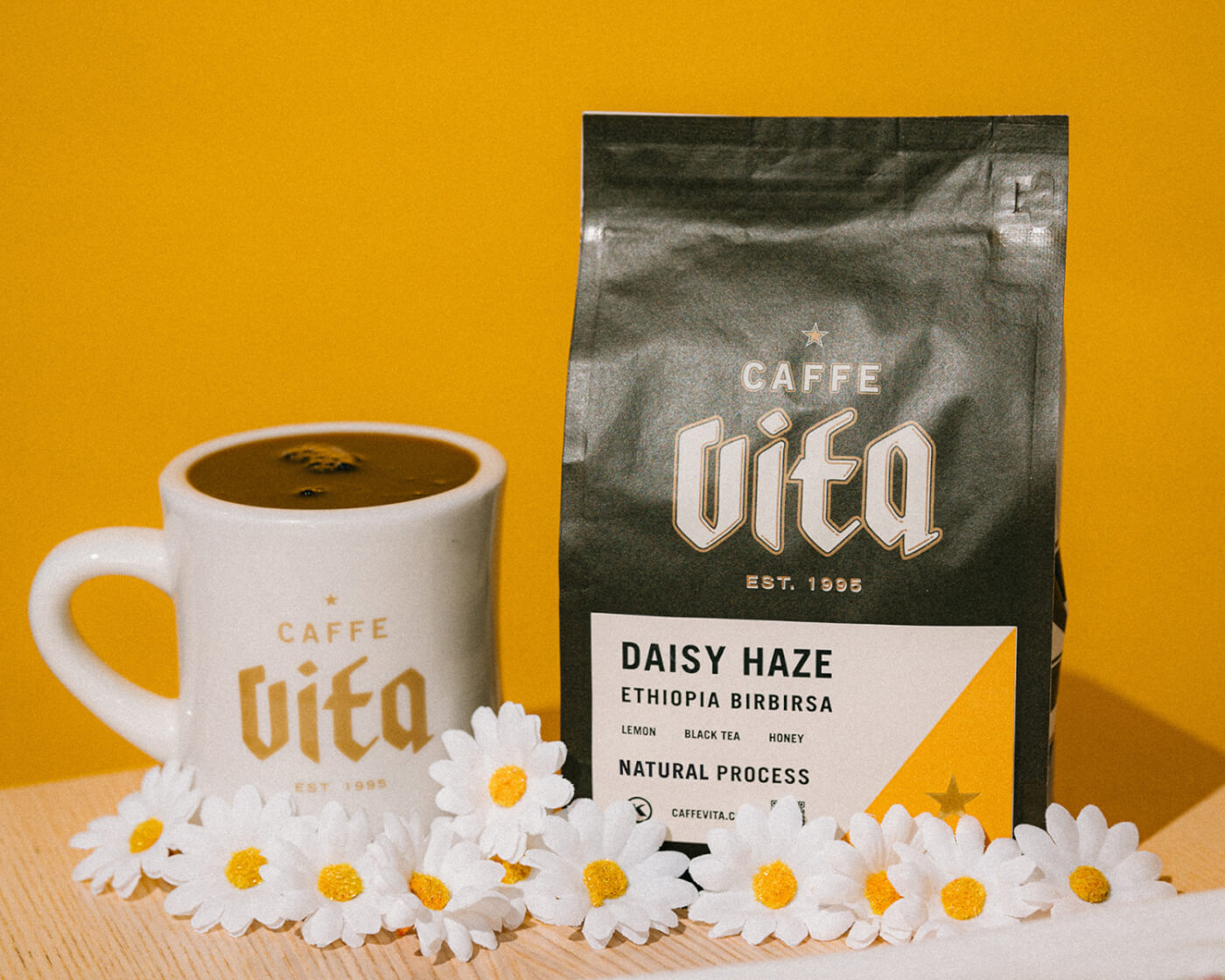 daisy haze coffee in a bag with a mug and daisies