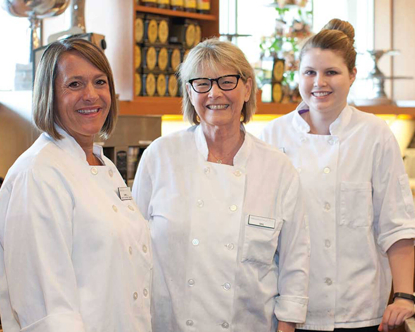 Three team members wearing white chef coats