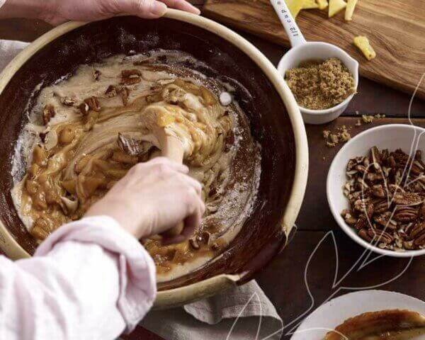 Baker mixing a large bowl of hummingbird cake batter.