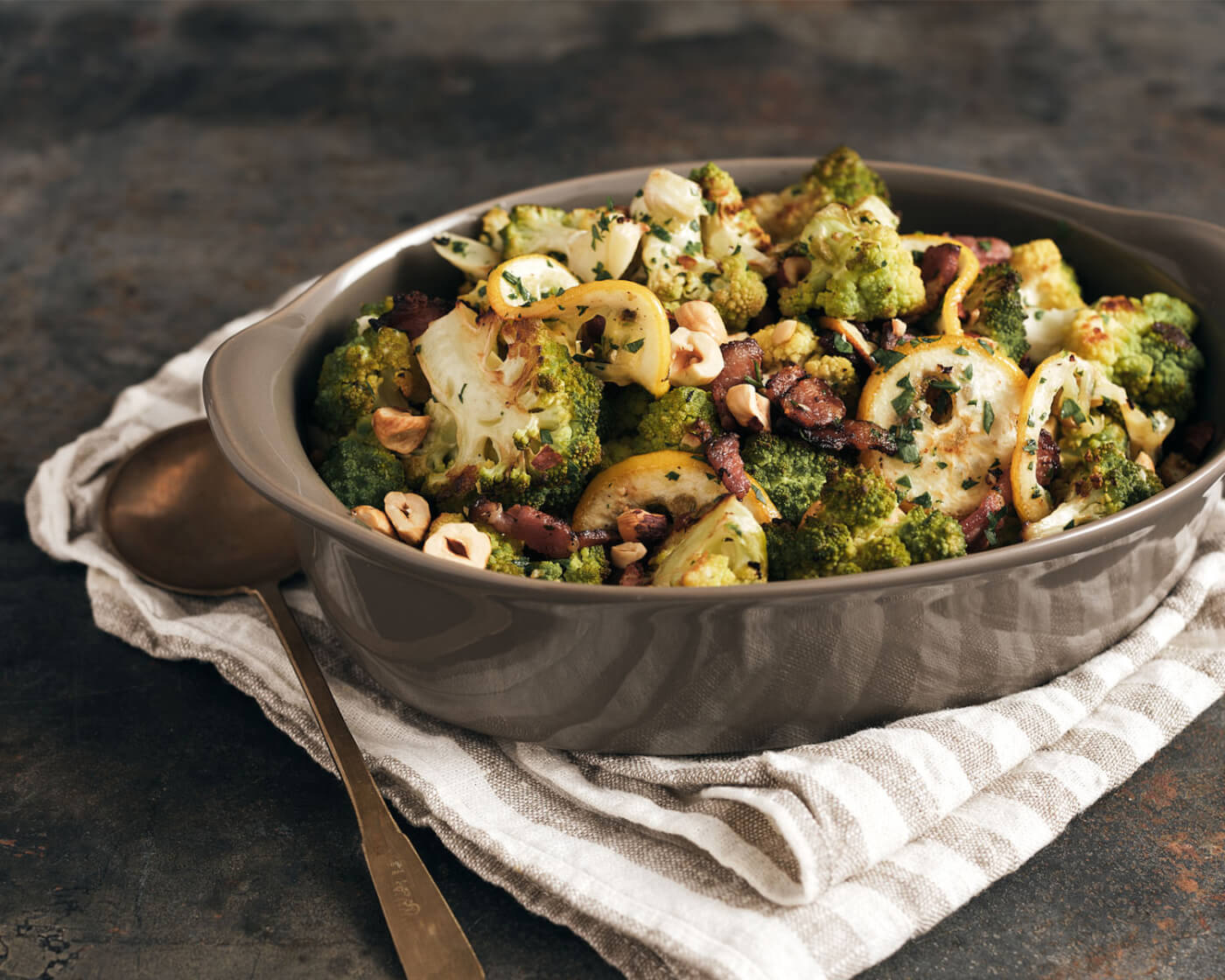 Roasted vegetables topped with bacon and hazelnuts.