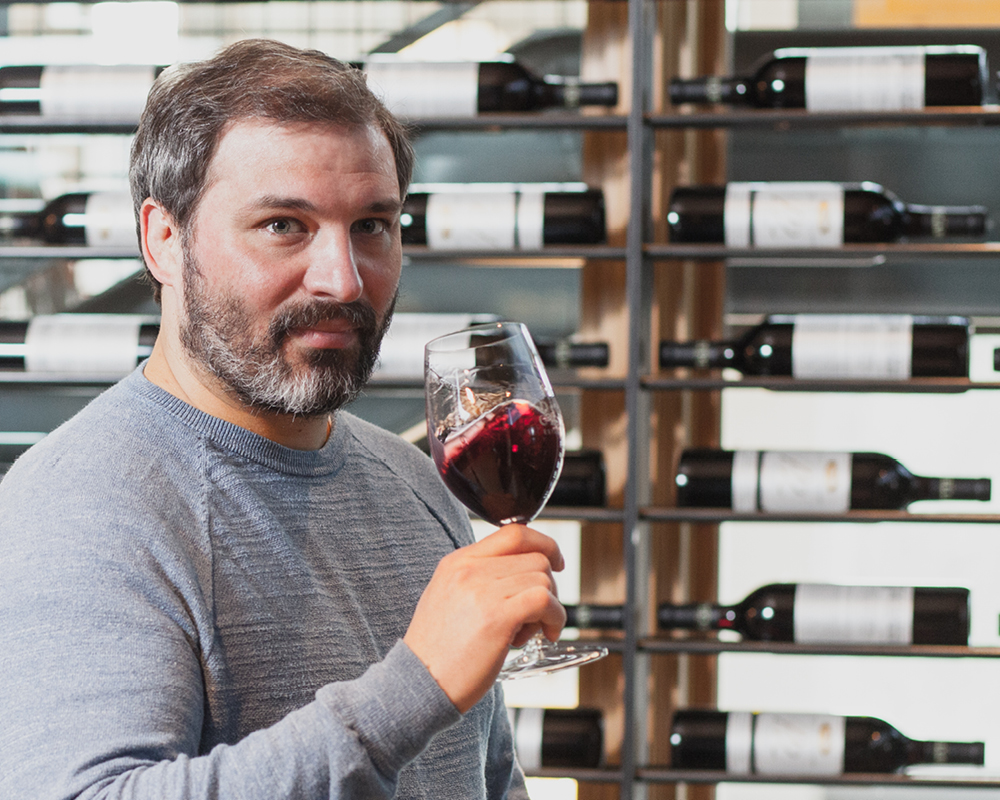 Jason Gorski posing with a glass of red wine