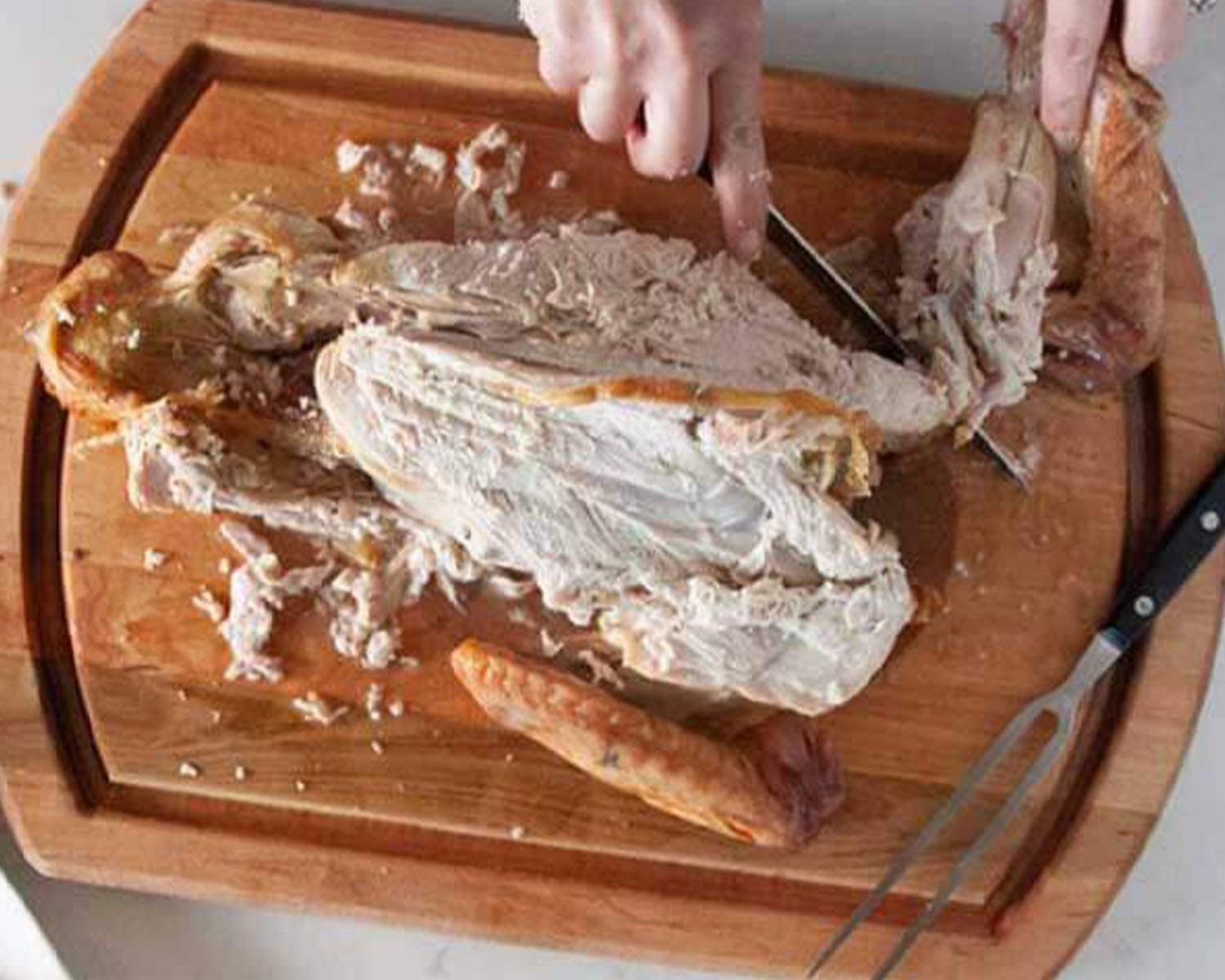 Turkey wing being removed with a carving knife