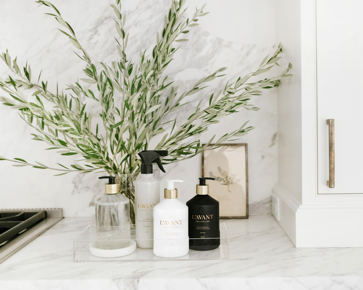 L'AVANT product on a counter in a white kitchen with foliage in the background.