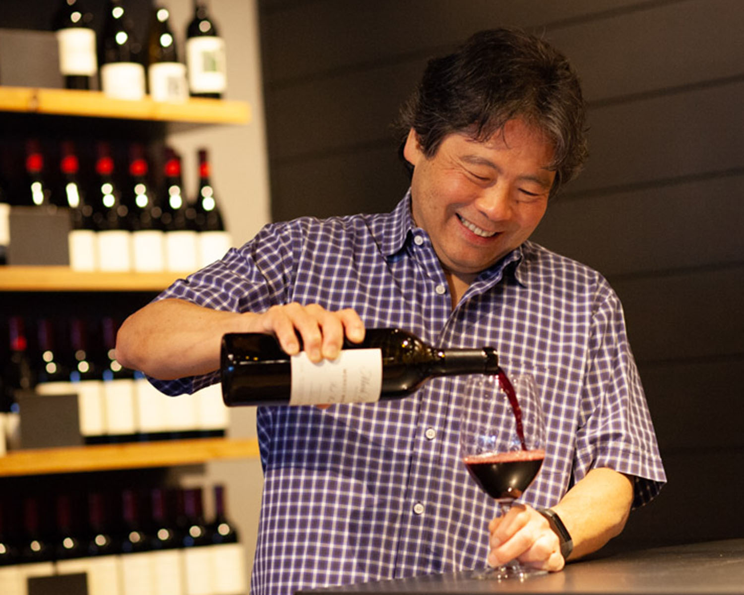 Mark Takagi pouring a glass of red wine