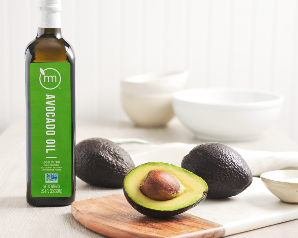 Avocado oil bottle styled with avocados