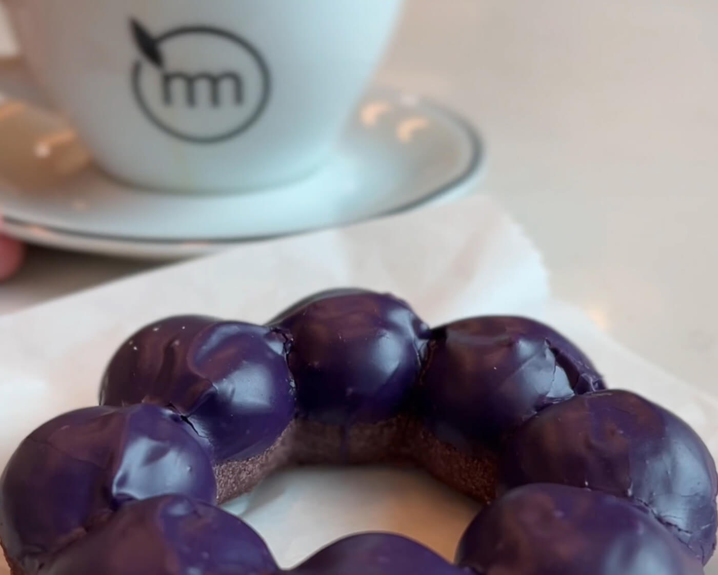 purple ube mochi donut and coffee cup