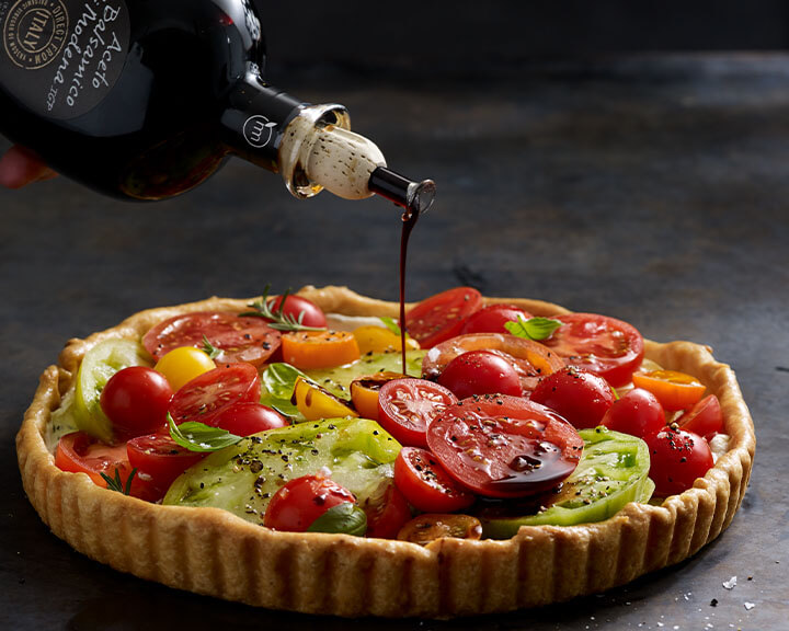 Balsamic vinegar drizzled on a tomato tart