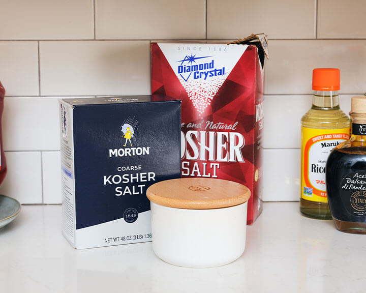 Packages of salt on a pantry shelf.