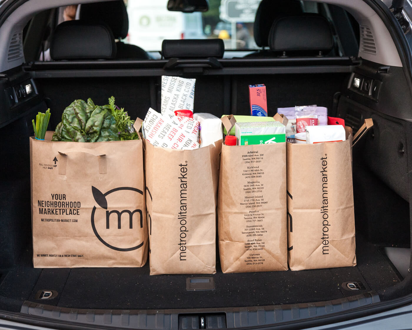 Full grocery bags in the back of a suv.