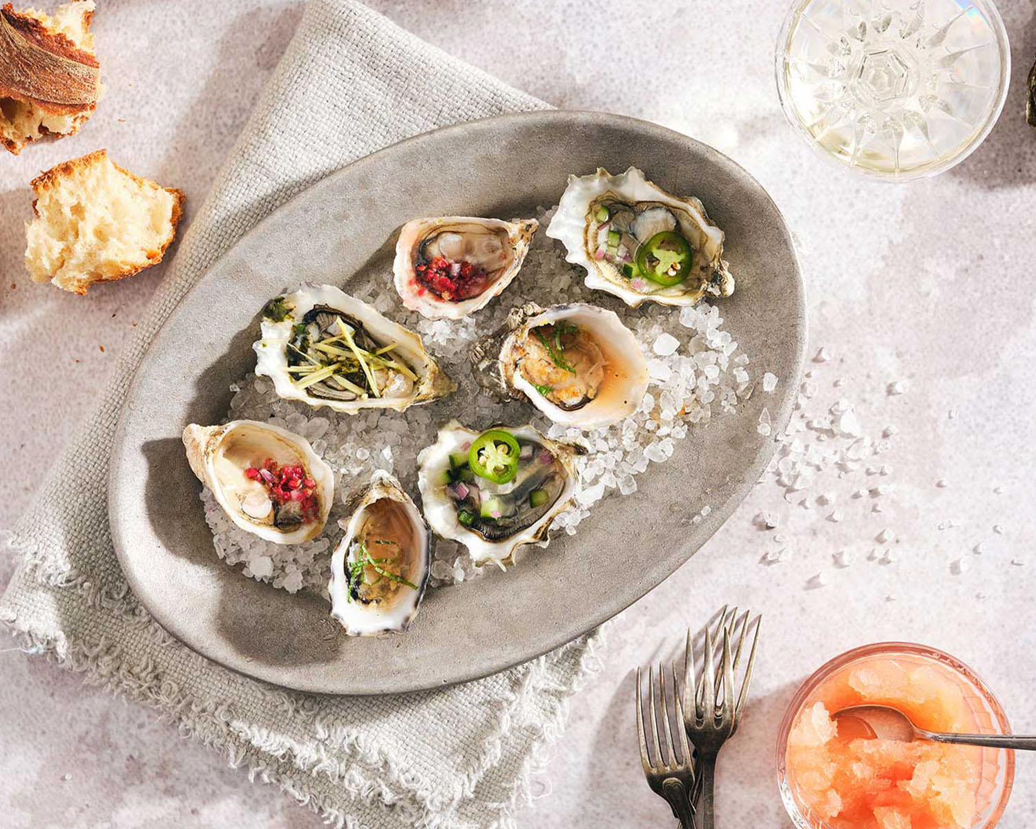 a plate of oysters on the half shell with garnishes