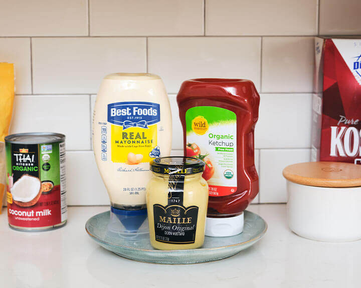 Various sauces on a pantry shelf.