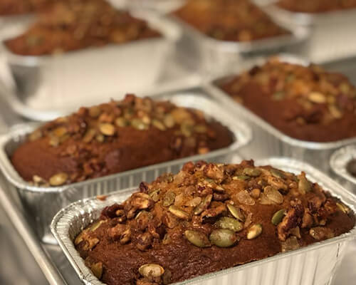 Loaves of harvest bread topped with pumpkin seeds.