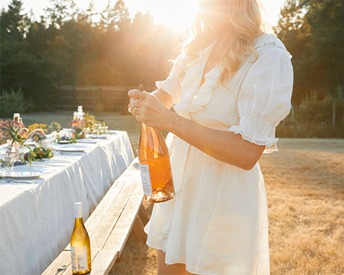 Audra Lawlor opening a bottle of wine.