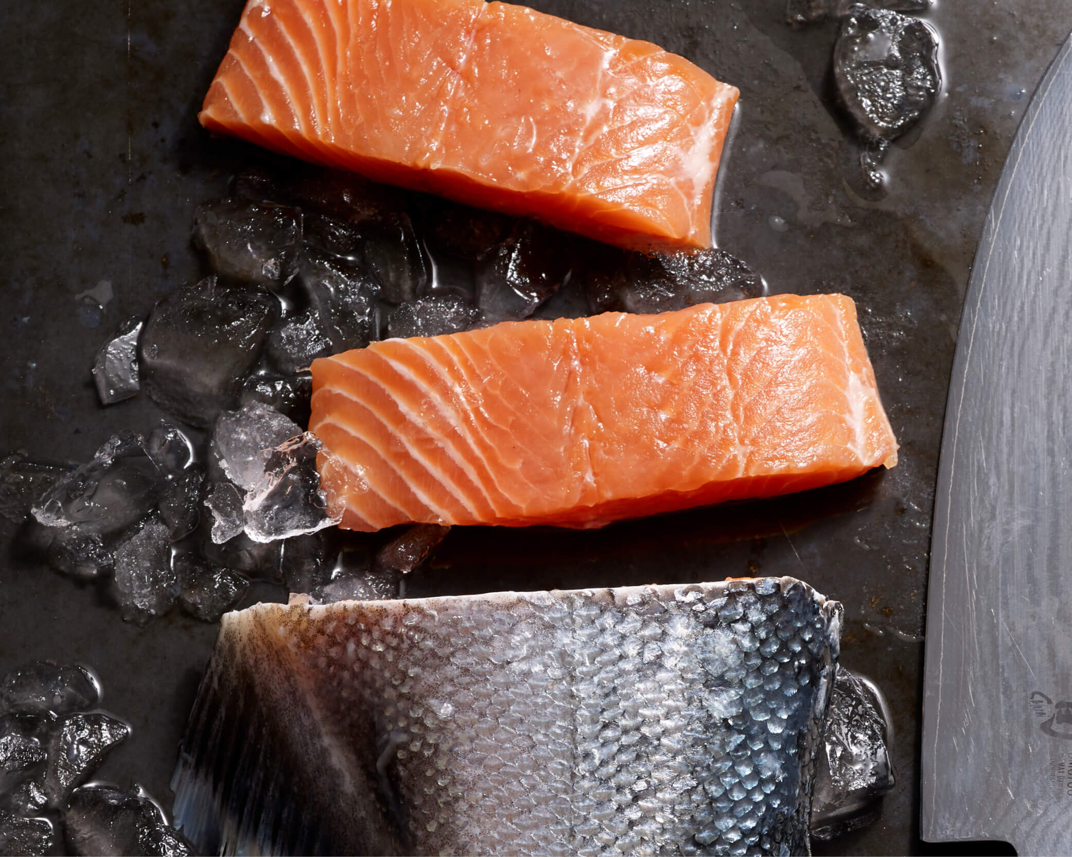 Fresh salmon on a cutting board with a knife.